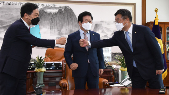 윤호중(오른쪽) 민주당 원내대표와 김기현(왼쪽) 국민의힘 원내대표가 28일 국회에서 박병석 국회의장 주재로 열린 언론중재법 관련 회동에서 주먹인사하고 있다. 국회사진기자단=연합뉴스